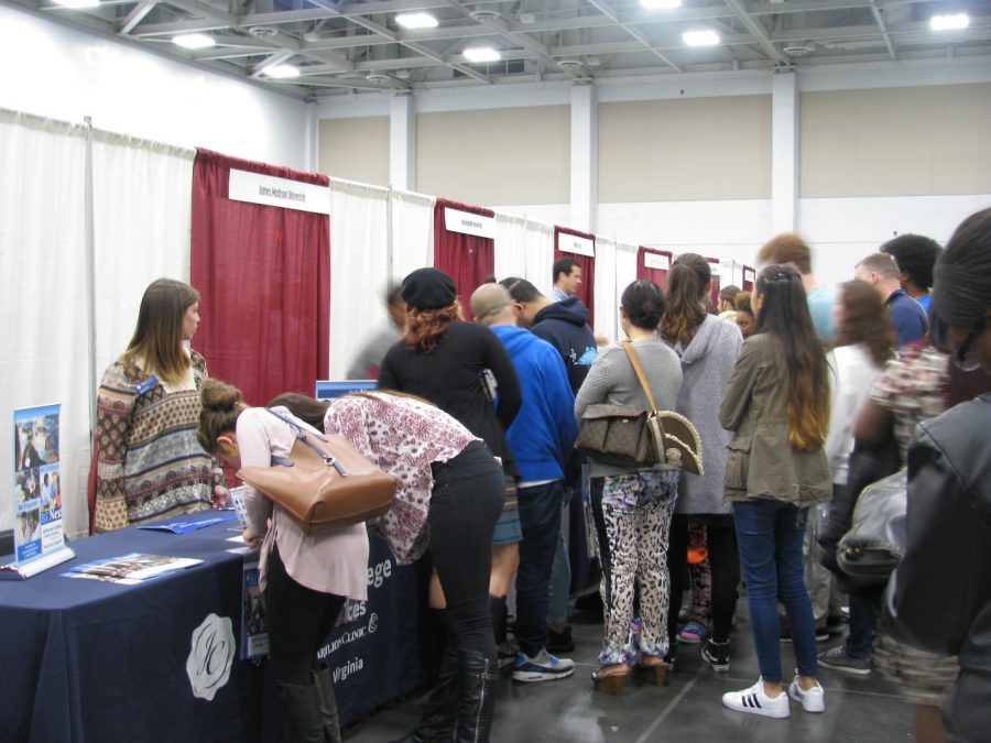 College and university representatives stand at their booths to hand out informative brochures and answer questions for prospective students at the Virginia Beach Convention Center.