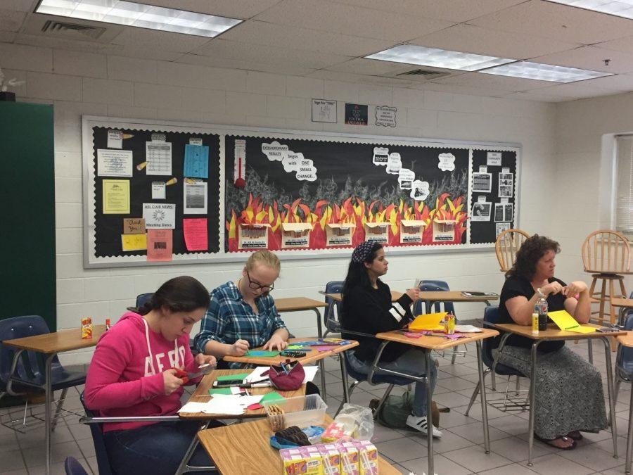 American Sign Language Club members [left to right] Ana Martinez-Xacur, Josephine Bradley, and Karines Velasquez, as well as club sponsor Jenny Bradley, create Christmas cards to send to a local homeless shelter at their meeting on November 30. 