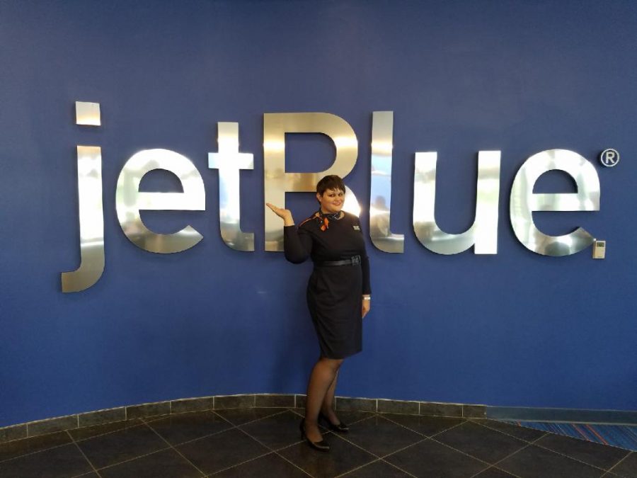 Depicts Katrina Miller in her flight attendant attire standing near the  
airline logo she works at. Photo by Makenna Miller 