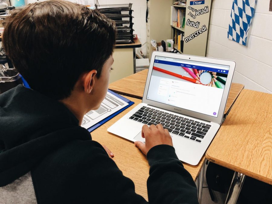 Freshman Caillou Sleiman uses a laptop to check Google Classroom. 