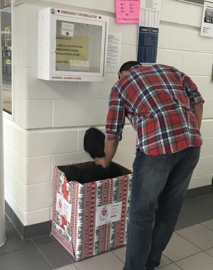 Senior Wilson Vega shuffles through the coat bin as he considers making a donation to the coat drive, which ended prior to the holiday break.