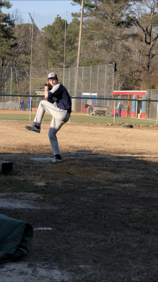 Junior Micah Singer warms up by practicing his pitching. 