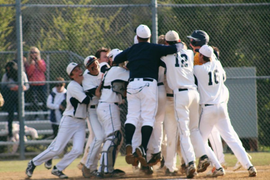 The+baseball+team+jumps+together+in+celebration+of+their+win+against+First+Colonial+on+April+17.+