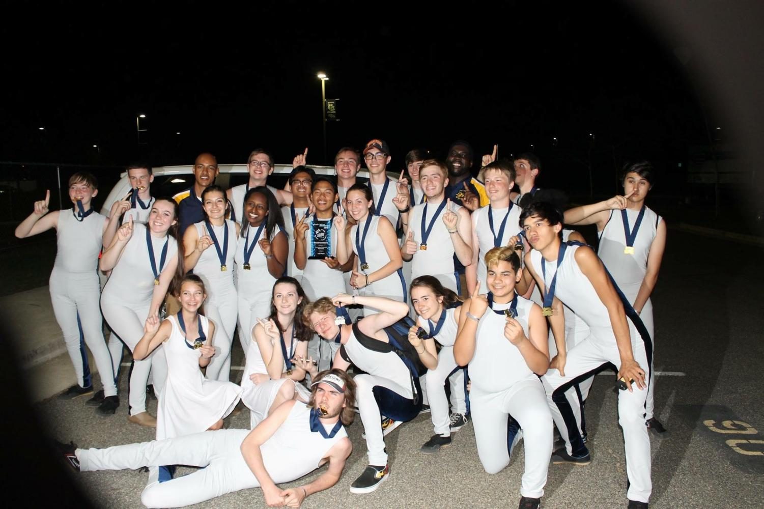 Indoor drumline celebrates their first place win with a trophy and gold medals for all team members in the South County High parking lot.

