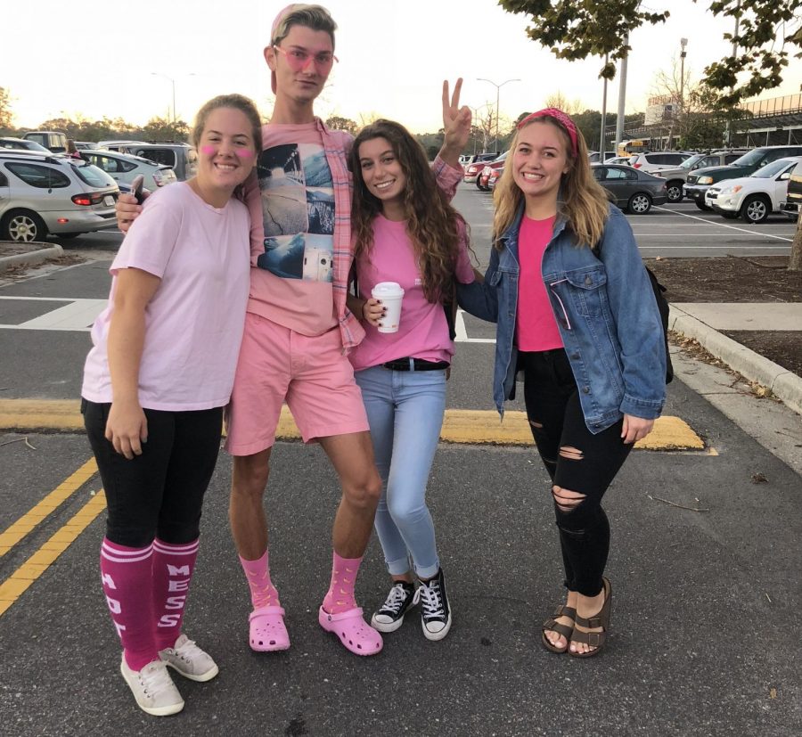 Seniors (left to right) Kayley Brennan, Tristan Hicks, Rachelle Jacob, and Dillan Alspaugh show their pink outfits in the student parking lot before school. Photo on Oct. 19