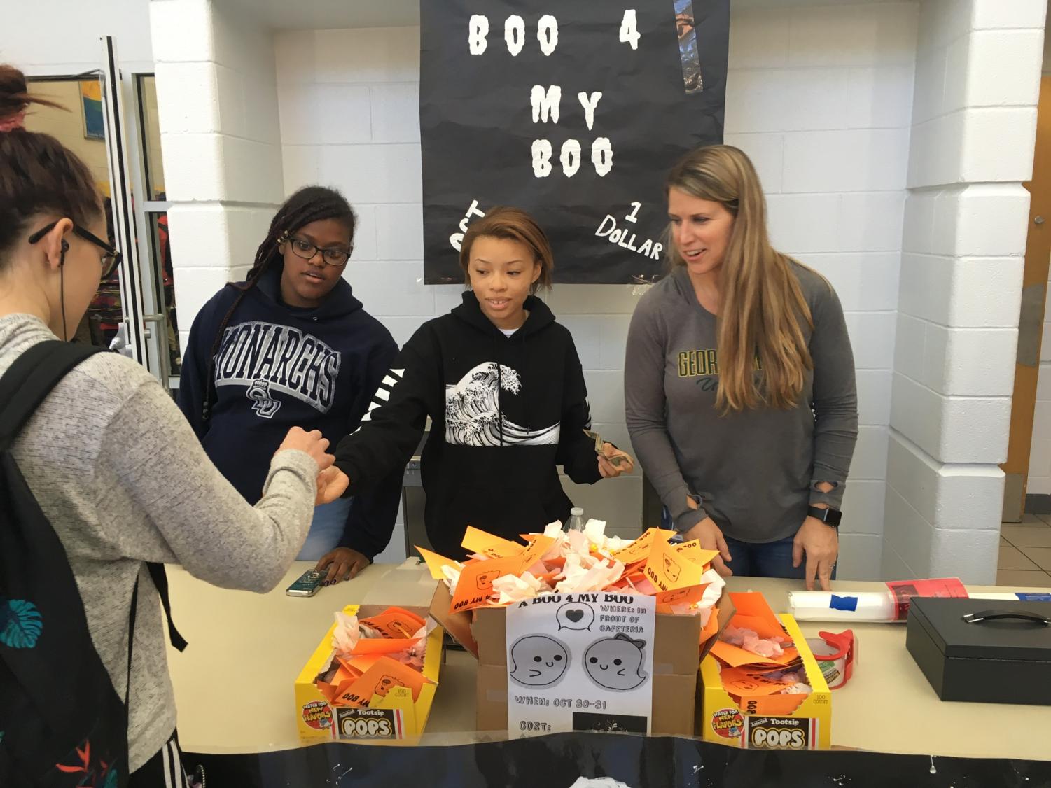 AVID students and coordinator Michelle McAfee sold decorated Tootsie Pops to students outside the cafeteria for $1 each. Oct. 30, 2018.