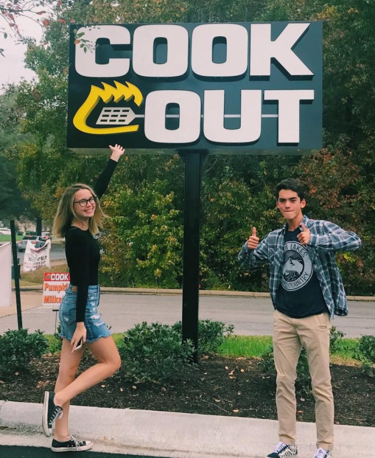 Rachel Vincent and Stephen Kelley pose in front of the Cook Out sign on November 2. 