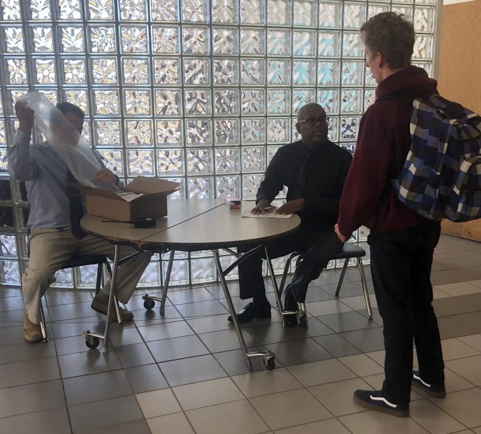 MSA Coordinator and Counselor Bryan Everett prepare to pay senior Joseph Mastrullo on Oct. 31 in the cafeteria.