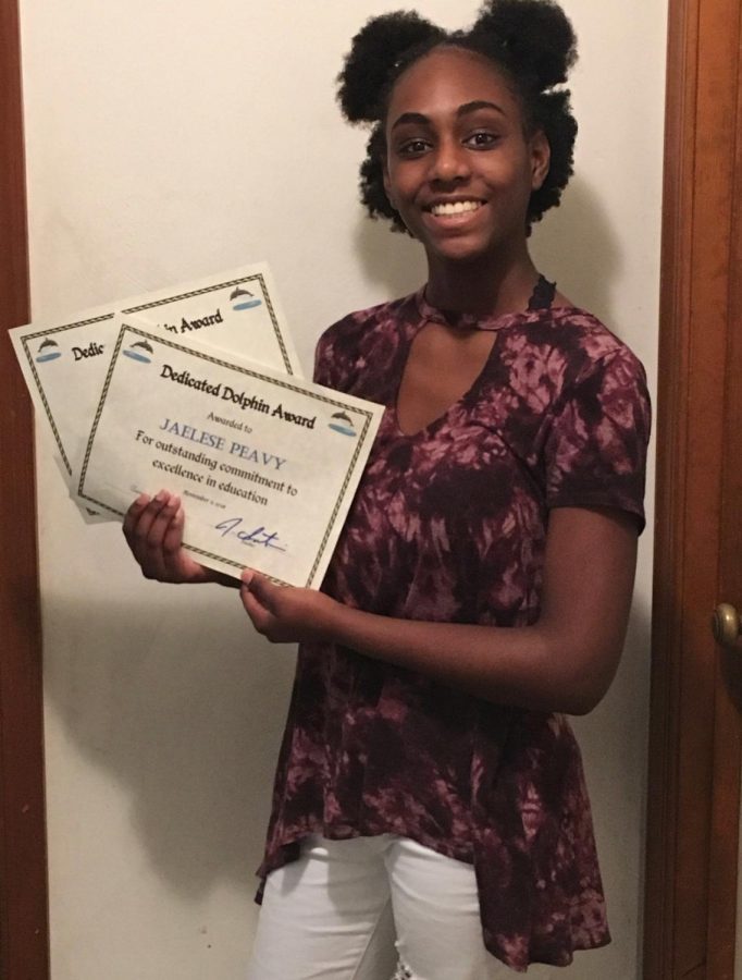 Junior Jaelese Peavy poses with two of her Dedicated Dolphin awards on Nov. 15. Photo taken on Nov. 15. 