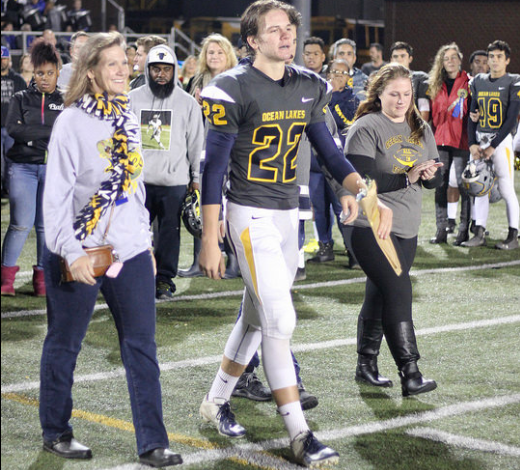 Xander Jedlick walks with his family on the Kellam football field for the Dolphins senior night on Nov. 9. 
