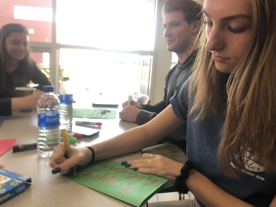 (Left to right) Briannah Hawley, Jake Low, and Haley Tiedeman create their personalized holiday cards to send to those in service in the cafeteria on Dec. 7.