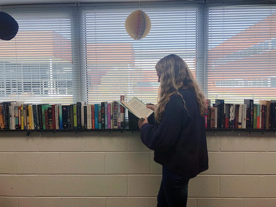 Junior Isabelle Weiss checks out a copy of Frat Girl, by Kiley Roache, during her fourth block English class. Photo by Katie Kerrigan.
