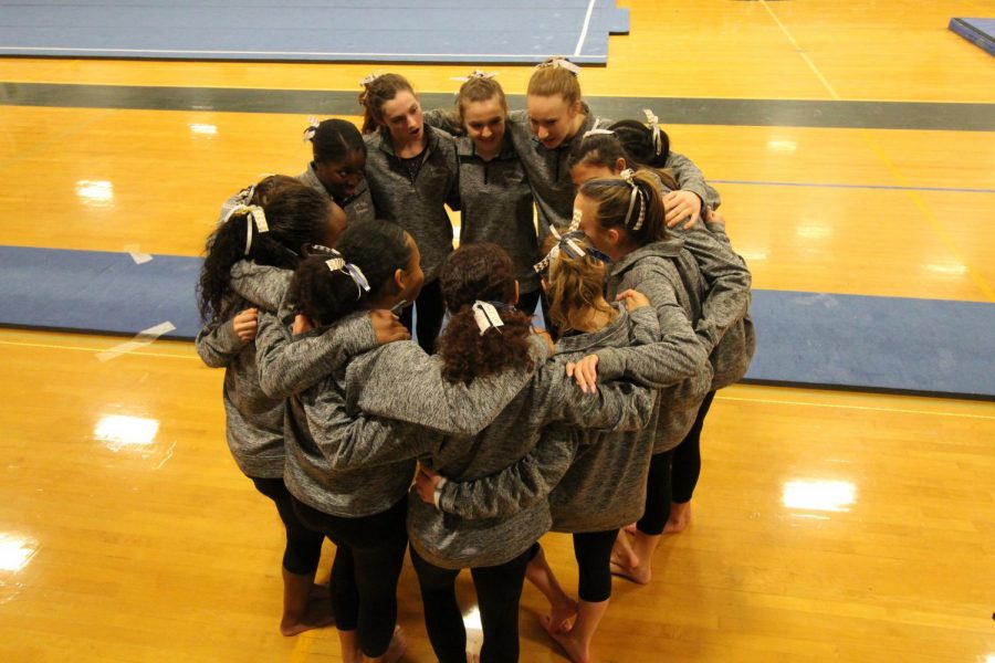 The gymnasts circle up for a pre-meet huddle, Monday, Jan. 7.
