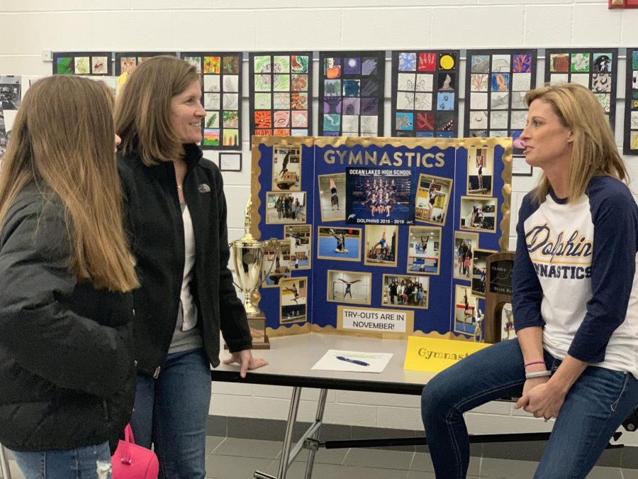 Gymnastics coach and physical education teacher Jennifer Ramey introduces gymnastics to a rising freshman and her mother on March 6 at the school’s main entrance.
