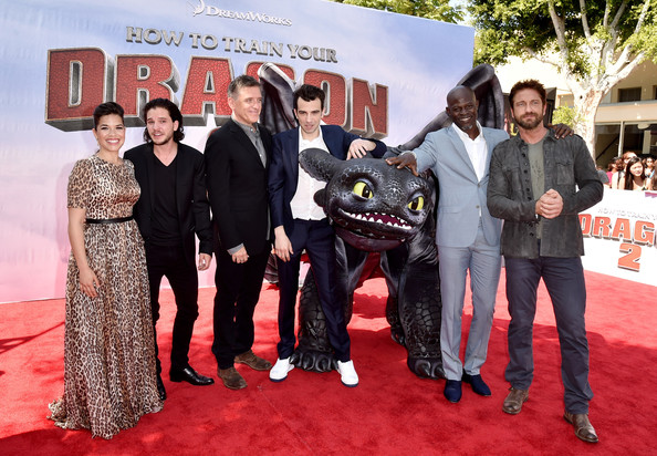 Depicts Gerard Butler, Djimon Hounsou, Jay Baruchel, America Ferrera, Craig Ferguson, Kit Harington standing around a model of the dragon Toothless. Picture source from Zimbio.com. 
