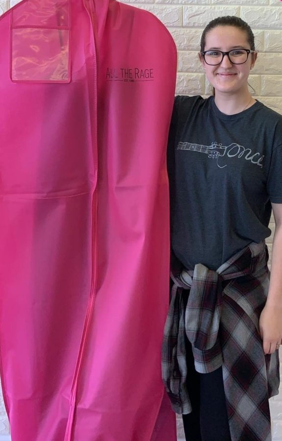 Senior Cheyenne Zawacki holds her prom dress inside a pink garment bag from All the Rage. Photo taken by Cheyenne Zawacki.