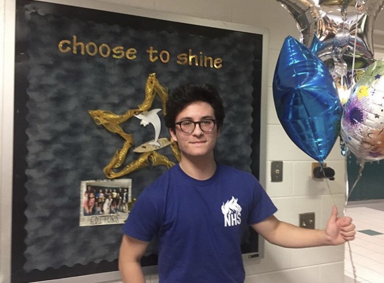 Keano stands with balloons after receiving the Brickell Academy scholarship.

