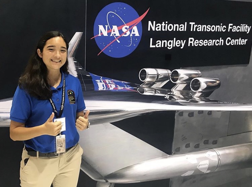 Maren Kelley smiles in front of a sculpture at NASAs  Langley research center.
