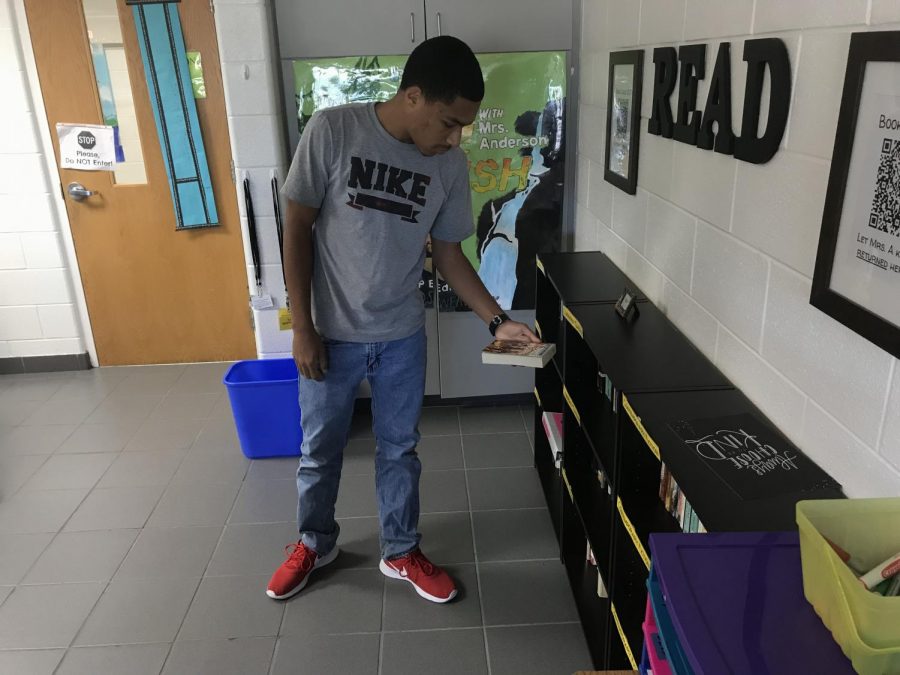 Senior Xavier Adams browses Katie Andersons catalog of books on Sept. 20, 2019. 