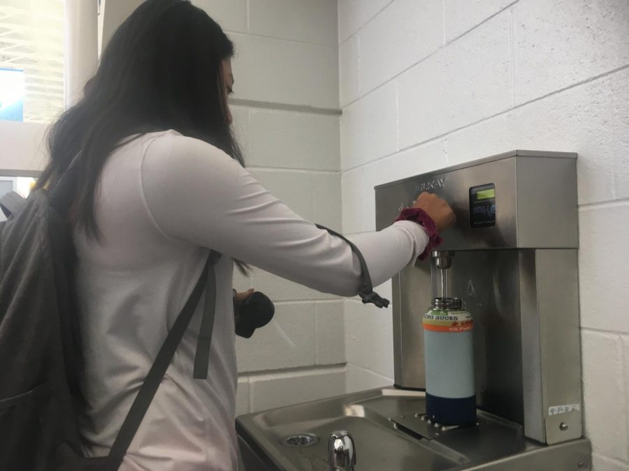 Junior Nina Dao refills Hydroflask using Elkay water fountain, located in the cafeteria foyer.