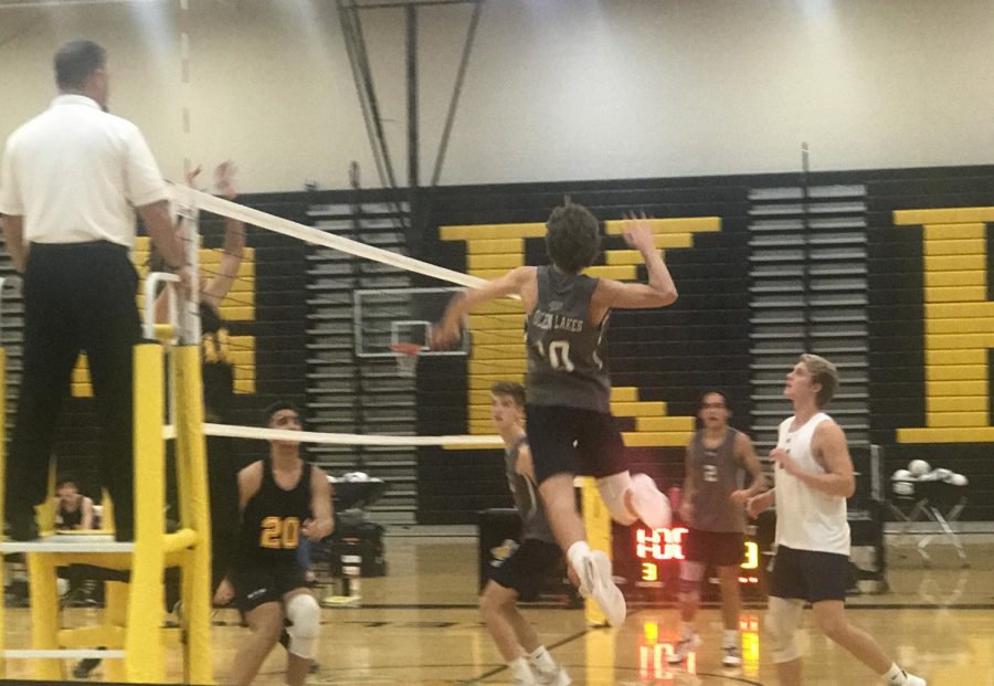 Noah Naas goes up to spike the ball after a set from Lucas Bushey.