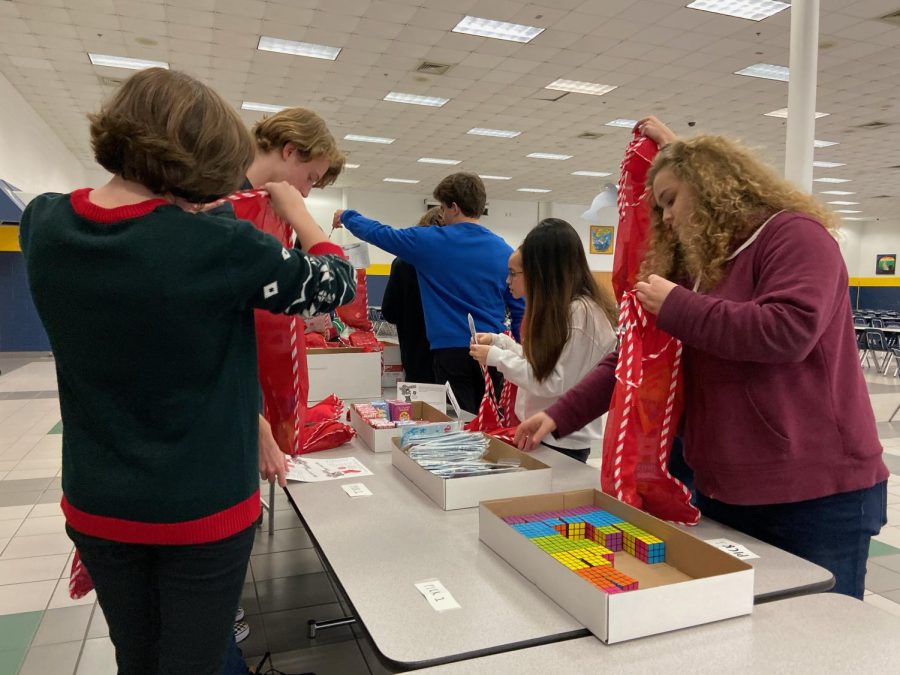 National Honor Society members stuff stockings for children in need at the winter social in the cafeteria. This article was published in modified form for the Stall Seat Journal.