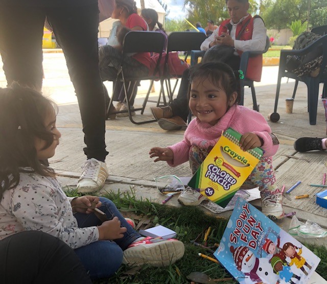 Two-year old Naydelyn opens colored pencils to color on the first day of screening. 