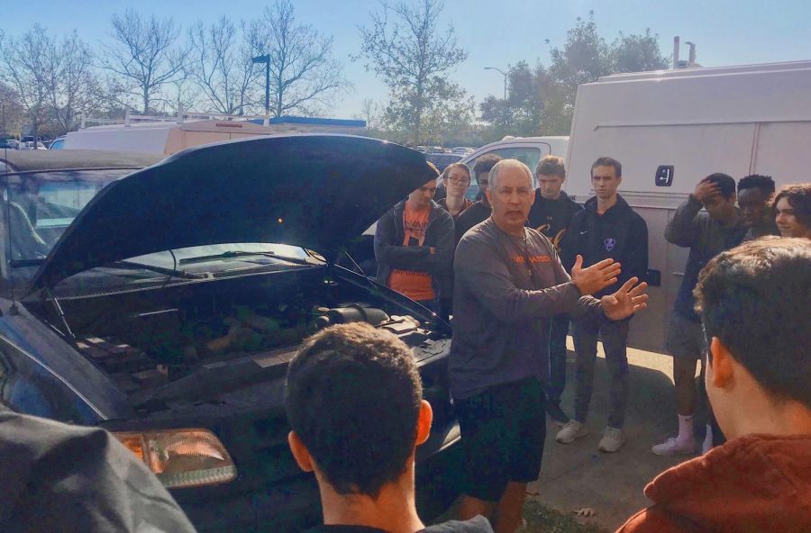 Students learn how to change a tire and jumpstart a car with health and PE teacher Pete Zell during their advisory block outside on Dec. 4. 