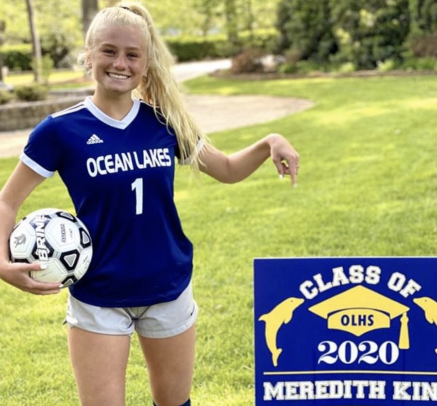 Senior Meredith King stands out in front of her yard with her graduation sign that was delivered on April 30 by teachers Gary Felch and John Kelley.