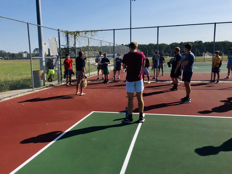 Wrestling team meets on tennis courts this fall and practices social distancing during conditioning.