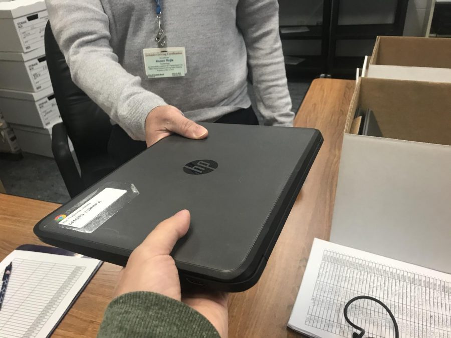 Student exchanges chromebook in room 101 