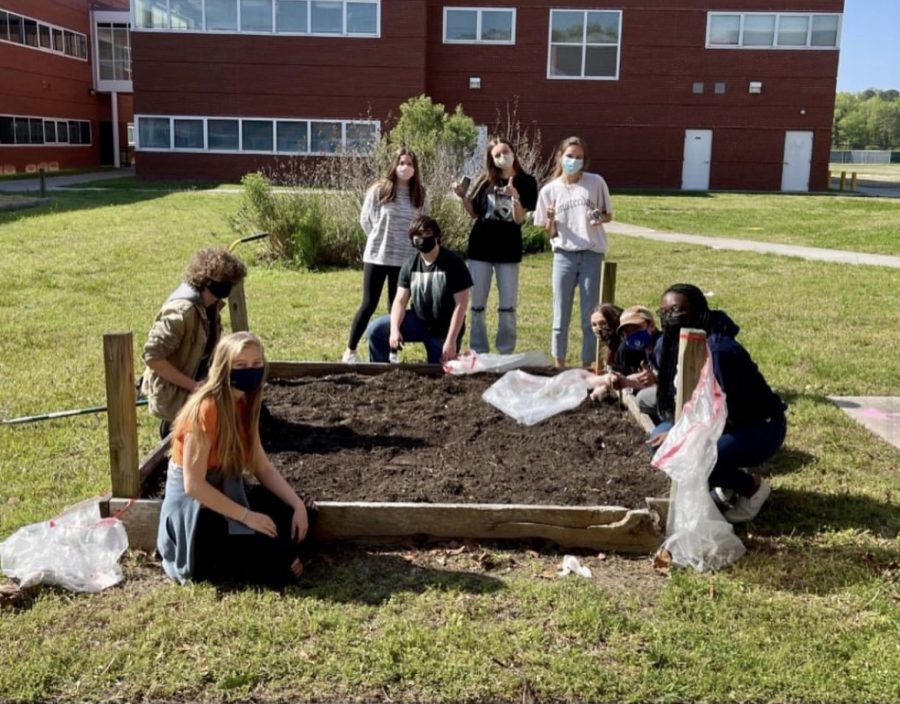 AP Environmental students finish cleaning out the flowerbed behind the cafeteria on April 22.

