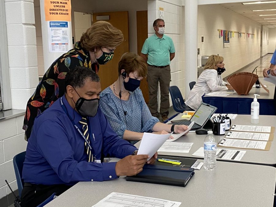 (From left to right) School administrators Steven Oberlander, Dr. Claire Leblanc, and Darcy Parker review papers regarding the first dose of the Pfizer vaccine. Picture taken May 25.