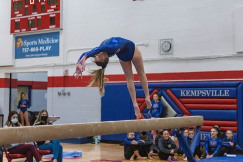 Senior Sam Lee finishes up her bar routine as fellow teammates watch enthusiastically at Kempsville High School on Jan. 10.