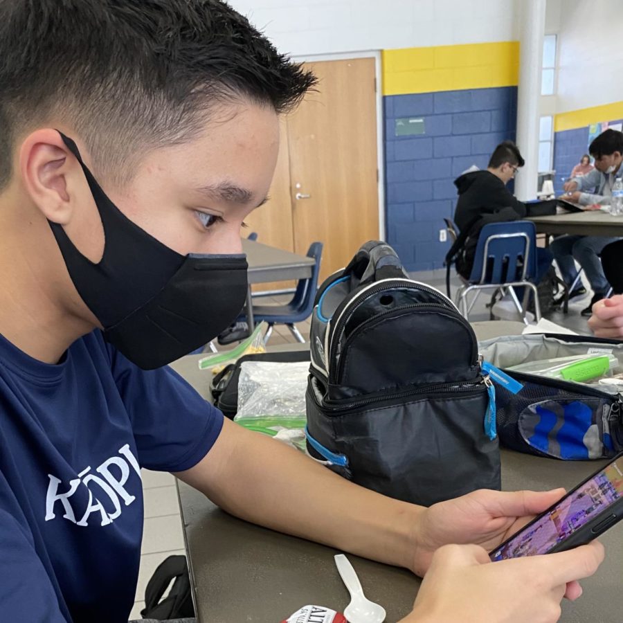 Freshman+Kai+England+using+his+phone+to+play+Clash+Royale+on+March+17.