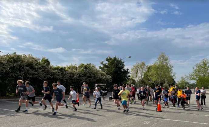Participants of the Dolphin Dash 5k race at the start line in the student parking lot on April 30, 2022.
