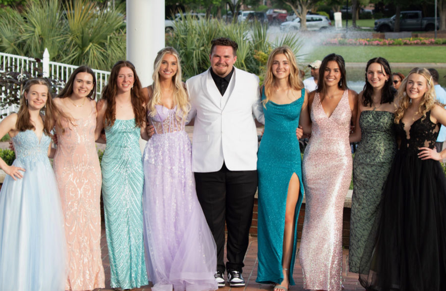 Senior+Hunter+Dinsmoor+enjoys+a+photo+with+friends+at+prom+2022.+The+Enchanted+Garden+was+the+theme.+