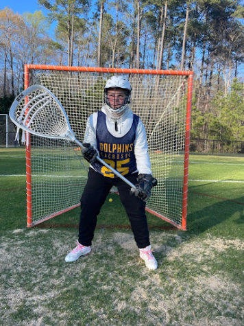 Freshman and team co-captain on the varsity lacrosse team, Chloe Purvis practices her goalie skills April 1, 2022.