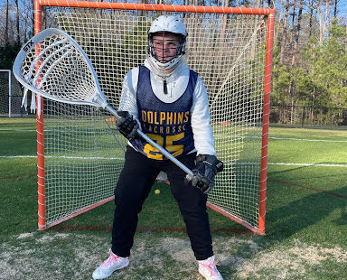 Freshman and team co-captain on the varsity lacrosse team, Chloe Purvis practices her goalie skills April 1, 2022.