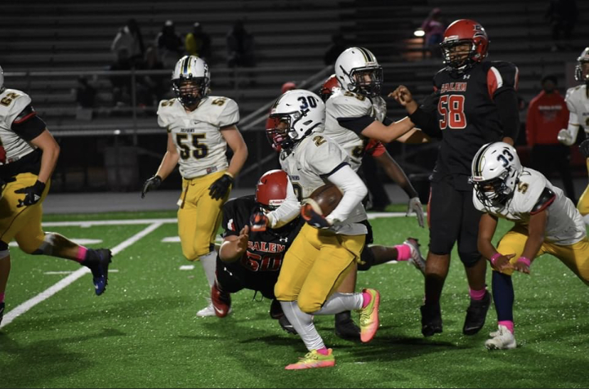 Darian McKenzie runs with determination to get his second touchdown of the night on Oct. 20, 2023,  while his teammates guard him to ensure he does not get tackled.