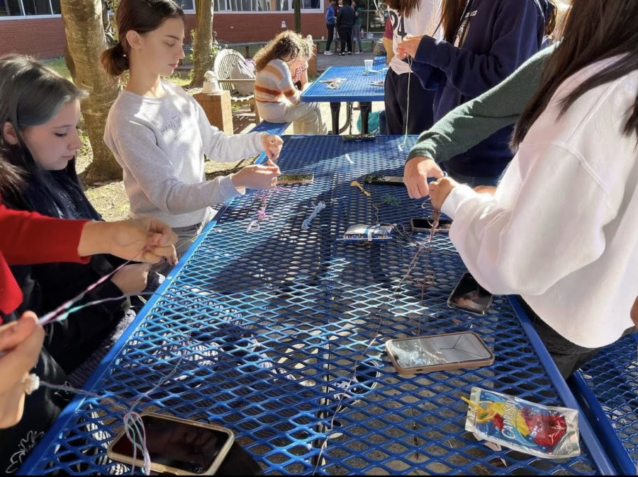 Freshman+Katherine+Elliot+and+Katherine+Harrison+make+friendship+bracelets+for+patients+at+CHKD+receiving+cleft+palate+surgery+on+Thursday%2C+Oct.+20%2C+2022%2C+in+the+schools+courtyard.+