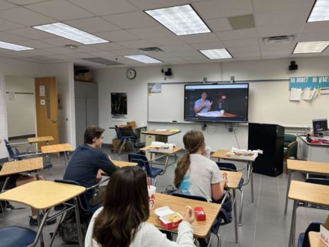 Club Members, Ben and Gracie Tignor, and junior Melanie Dunaway, enjoy donuts and Chick-fil-a as they watch a video from a series of Tim Tebow, who is renowned  speaker about the Bible, on Nov. 2, 2022, in room 137.