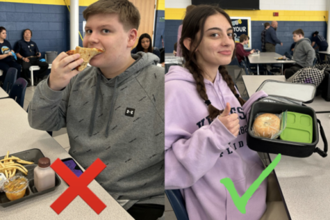 Sophomore Ian Brite eats school lunch, while freshman Katherine Elliot enjoys a home made lunch in the school’s cafeteria on Dec. 9, 2022.
