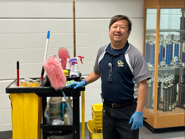 Ocean Lakes’ Custodian, Chi Ha, smiles as he moves to clean the music hallway on Jan. 27, 2023. 
