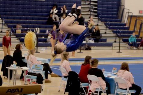 Mackenzie Murphy flips off the beam as she competes in the team competition at States on Feb. 18, 2023, at Lightridge High School. 