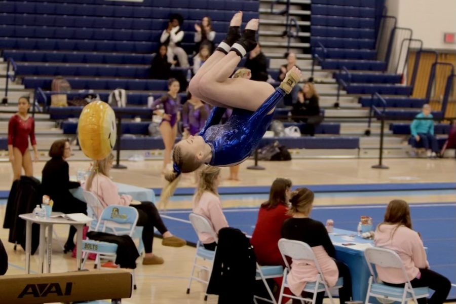 Mackenzie+Murphy+flips+off+the+beam+as+she+competes+in+the+team+competition+at+States+on+Feb.+18%2C+2023%2C+at+Lightridge+High+School.+