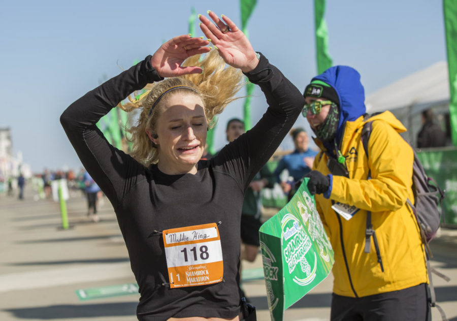 Madeleine King cries in joy as she breaks the tape as the first woman to cross the 2023 Shamrock Marathon finish line on March 20, 2023.