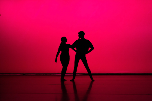 Silhouette of two JMU students dancing during the senior dance show piece in March, 2022.