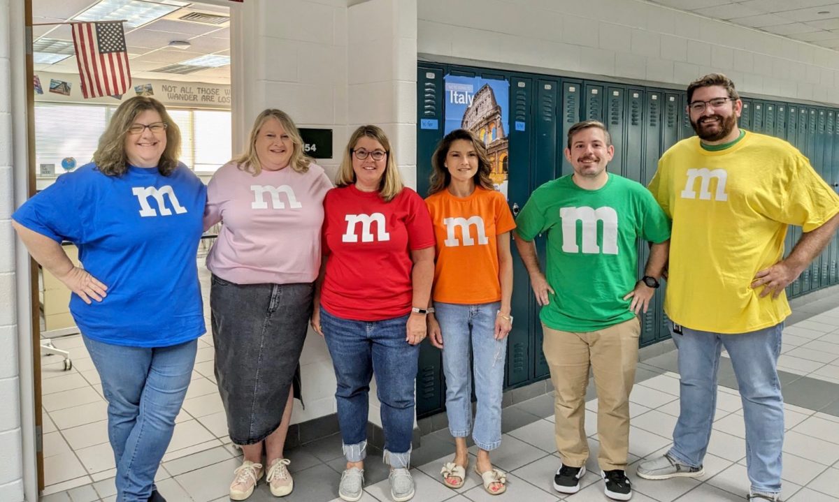 From left to right: History teachers Lisa Gibson, Darcy Pohl, Stasia LaRoche, Christine Steed, Mike Mosely and Jared Swift kick off spirit week by dressing as their favorite color of M&M for Dynamic Duo Day on Sept. 11, 2023. 