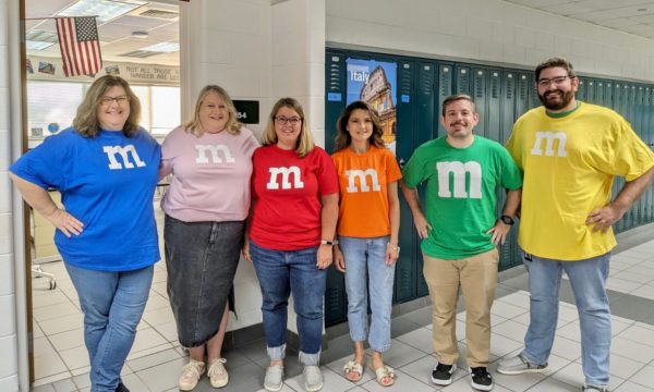 From left to right: History teachers Lisa Gibson, Darcy Pohl, Stasia LaRoche, Christine Steed, Mike Mosely and Jared Swift kick off spirit week by dressing as their favorite color of M&M for Dynamic Duo Day on Sept. 11, 2023. 